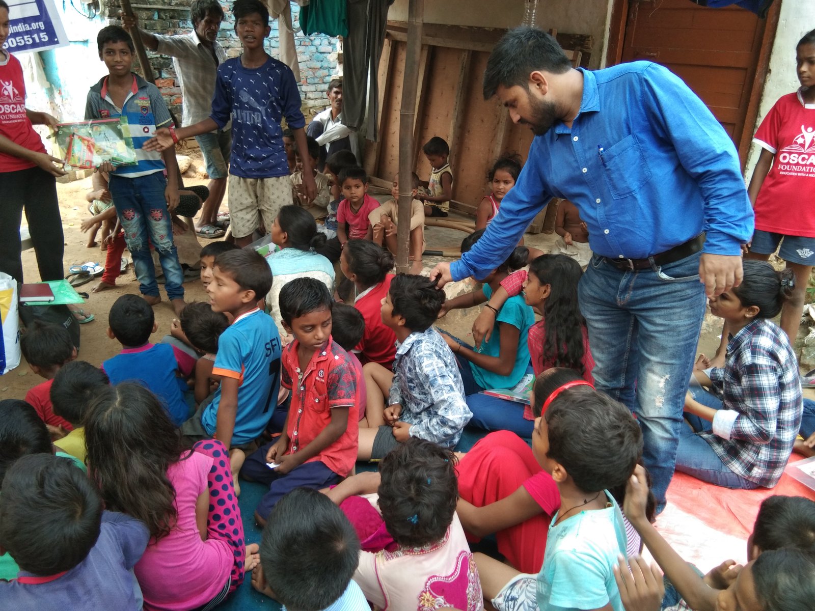 ARP volunteers distributing learning materials to children in a community setting